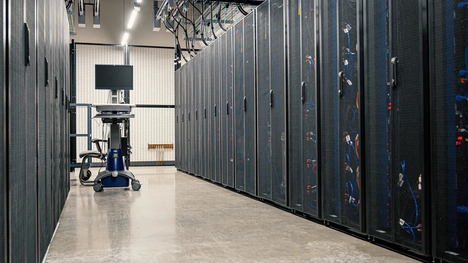 Coridor într-un centru de date cu rânduri de rack-uri de servere negre