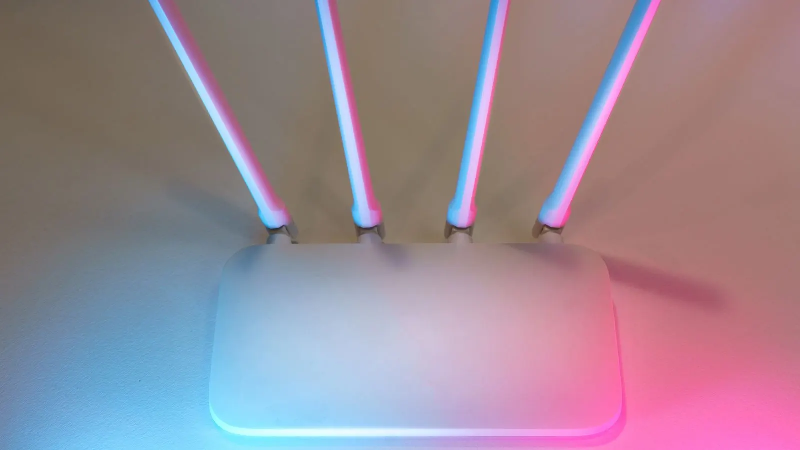 Router Wi-Fi alb cu patru antene, luminat în albastru și roz