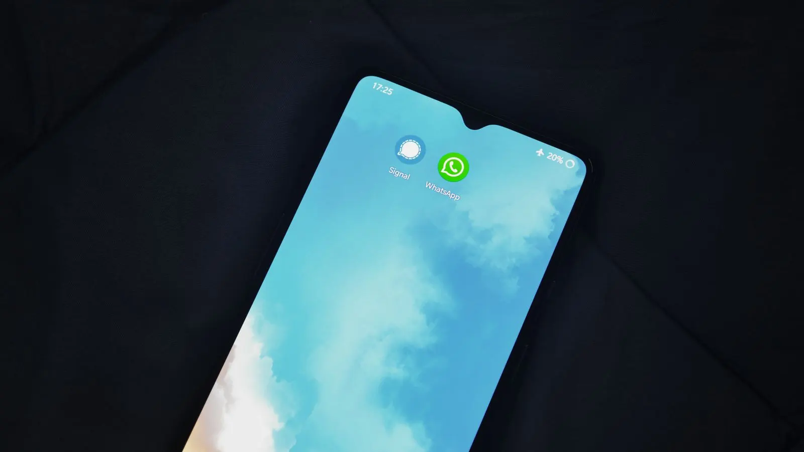 Ecran de telefon cu pictogramele aplicațiilor Signal și WhatsApp pe fundal albastru